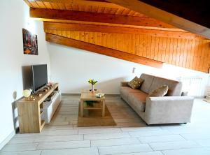 a living room with a couch and a tv at Annagaia Home in Bellizzi