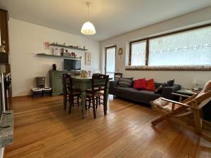 a living room with a black couch and a table at Residence I LAMPONI incantevole casa vacanze 6 posti letto con vista panoramica in Dimaro