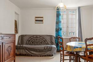 a living room with a table and a bed at Appartement 3eme étage in Castellane