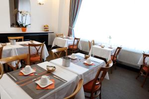 a dining room with white tables and chairs at Eurotel in Liège