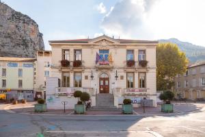 a building on a street in front of a mountain at Appartement 3eme étage in Castellane