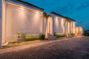 a row of white houses with palm trees on a street at The Alvarendra Ubud Villa By Bali Cabin in Ubud