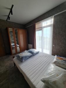 Saguramoにあるalexis saguramoの大きなベッドと窓のある寝室