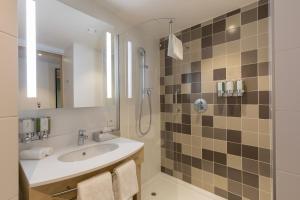 a bathroom with a sink and a shower at Hampton By Hilton Antwerp Central Station in Antwerp +48 photos