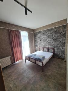 Un dormitorio con una cama y una pared de ladrillo. en alexis saguramo, en Saguramo