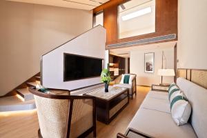 a living room with a couch and a tv at Wingate by Wyndham Yunfu Xinxing in Yunfu