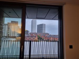 a view of a city from a window at Luxury 2 Bed Apartment, with a balcony city & canal view in Manchester City Centre! in Manchester