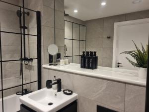 a bathroom with a sink and a shower and a tub at Luxury 2 Bed Apartment, with a balcony city & canal view in Manchester City Centre! in Manchester +14 photos