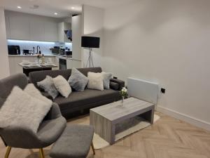 a living room with a couch and a table at Luxury 2 Bed Apartment, with a balcony city & canal view in Manchester City Centre! in Manchester