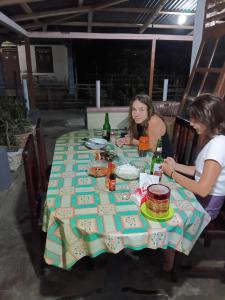 two women sitting at a table with food and drinks at Bunaken Jhon Homestay in Manado
