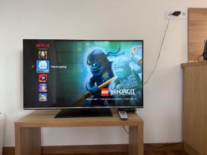 a flat screen tv sitting on top of a wooden table at Nature Escape Cottage in Protivín