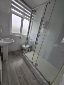 a bathroom with a shower and a toilet and a sink at Beach Hotel Torbay B&B in Paignton +36 photos
