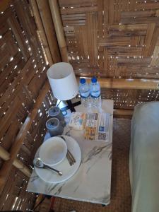 een tafel met een bord, een lamp en waterflessen bij Samui Camping Farm in Laem Sor +44 foto's