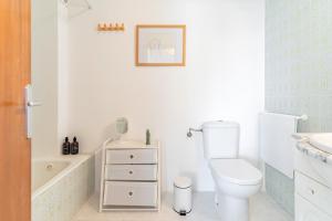 a bathroom with a toilet and a tub and a sink at Apartamento Mormor in Las Lagunas Mijas +12 photos