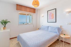 a white bedroom with a bed and a window at Apartamento Mormor in Las Lagunas Mijas