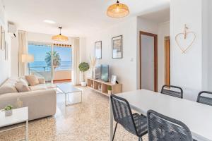 a living room with a couch and a table with chairs at Apartamento Mormor in Las Lagunas Mijas
