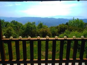 a wooden bench with a view of the mountains at Pangeo forest village in Mousthéni