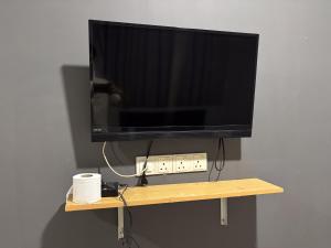 TV de pantalla plana en una estantería de madera en Ho Hotel Batu Berendam, en Malacca
