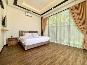 a bedroom with a bed and a large window at Palazzo Carangsari - 2-Bedroom Villa with Private Pool in Payangan