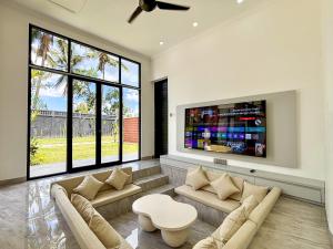 a living room with two couches and a tv at Palazzo Carangsari - 2-Bedroom Villa with Private Pool in Payangan