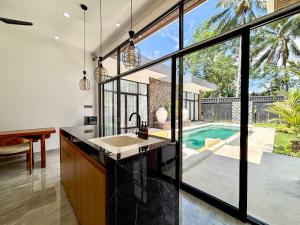 an open kitchen with a view of a pool at Palazzo Carangsari - 2-Bedroom Villa with Private Pool in Payangan