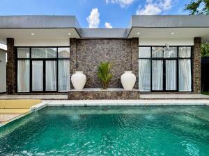 a swimming pool in front of a house at Palazzo Carangsari - 2-Bedroom Villa with Private Pool in Payangan