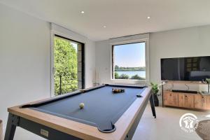 una mesa de billar en una habitación con una ventana grande en Ty bayon, en Belz