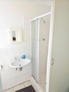 a bathroom with a sink and a shower at Pik & Pikkie Self catering apartments in Lambertʼs Bay