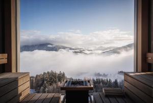 ein Zimmer mit Fenster mit Blick auf die Berge in der Unterkunft Alpin Panorama Hotel Hubertus in Olang