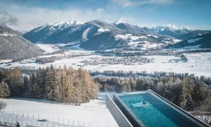 einen Whirlpool auf einem verschneiten Berg in der Unterkunft Alpin Panorama Hotel Hubertus in Olang