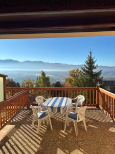 a table and chairs on a deck with a view at Le cocon du Canigou in Font-Romeu