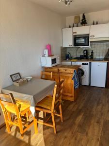 a kitchen with a table and chairs in a room at Le cocon du Canigou in Font-Romeu