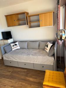 a bed in a room with a couch and cabinets at Le cocon du Canigou in Font-Romeu