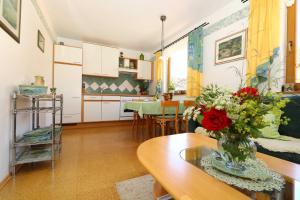 Eine Küche und ein Wohnzimmer mit einer Blumenvase auf einem Tisch in der Unterkunft Limerhof in Waischenfeld