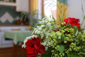 ein Strauß roter Rosen und anderer Blumen in der Unterkunft Limerhof in Waischenfeld