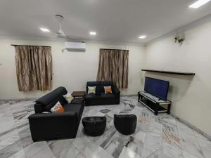 a living room with a couch and a television at Be Stay Ipoh with parking - 14pax, 5Rooms in Ipoh