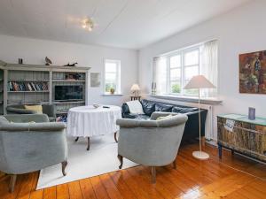 a living room with a couch and chairs and a table at 6 person holiday home in Ålbæk in Ålbæk