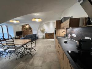 a kitchen with a table and chairs in a room at Les Serres d'Antan in Le Glaizil