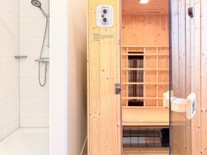 ツィングストにあるZingstroseのバスルーム(木製のドア付きのシャワー付)