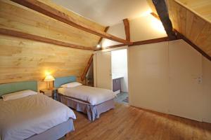a bedroom with two beds in a room with wooden ceilings at Le moulin in Nexon +51 photos