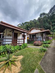a house with a garden in front of it at Chalés Metanóia in São Pedro da Serra