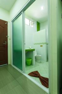 a bathroom with a toilet and a glass shower door at S Hotel Kanchanaburi in Kanchanaburi