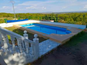 une piscine avec une clôture blanche dans l'établissement Casa rural en Casas de Moya 'Casa del Pino Gori', à Casas de Moya