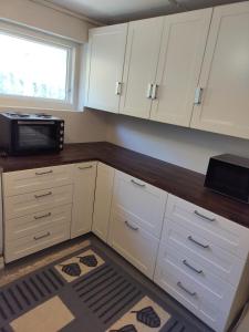 a kitchen with white cabinets and a microwave at Prekestolen, Pulpit Rock in Strand