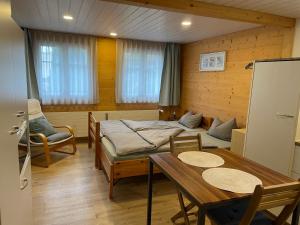 a room with two beds and a table and chairs at Bijou 1 Hübsche 1 Zimmer Wohnung in Herisau