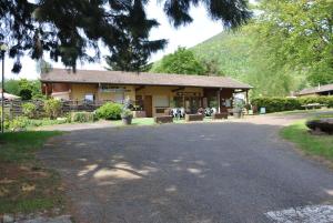 a building with a table and chairs in front of it at Camping du Haut-Koenigsbourg - Onlycamp in Lièpvre