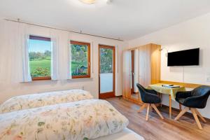 a bedroom with a bed and a desk and a television at Pension Schneider in Freiamt