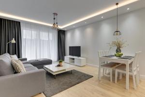 een woonkamer met een bank en een tafel bij Angielska Grobla - City Center, Marina & Parking by Downtown Apartments in Gdańsk +42 foto's