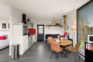 a kitchen and living room with a table and chairs at NEW! Vakantiehuis Grijpskerke met airco en houtkachel - 2 personen in Grijpskerke +14 photos