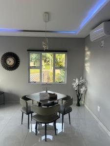ein Esszimmer mit Tisch und Stühlen und einem Fenster in der Unterkunft Kys Place in Durban